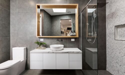 A sleek modern bathroom featuring a stylish shower, elegant sink, and contemporary toilet, exuding luxury and comfort.